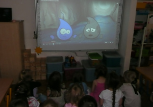 dzieci oglądająfilm na tablicy interaktywnej "Niezwykła podróż kropelki"