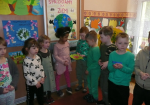dzieci ze wszystkich grup wiekowych przekazują sobie liść z naklejoną biedronką