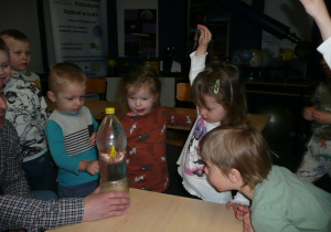dzieci podczas wykonywania eksperymentu z butelką plastikową