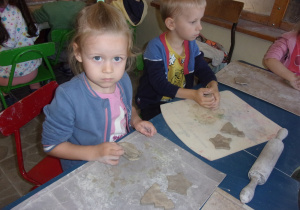 dzieci przy stoliczkach podczas warsztatów z gliny