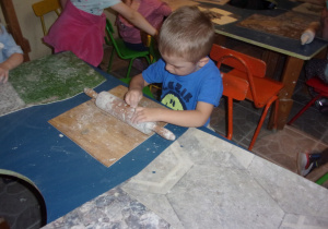 chłopiec przy stoliku podczas warsztatów z gliny