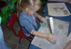 dziewczynka przy stoliczku podczas warsztatów z gliny