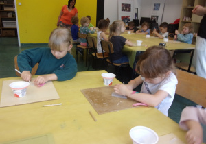 dzieci przy stolikach kroją masę glicerynową