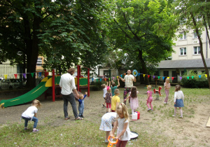 dzieci w ogrodzie przedszkolnym bawią się bańkami mydlanymi