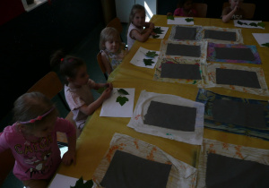 dzieci układają liście na papierze