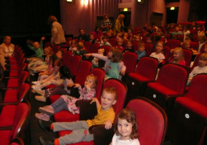 dzieci siedzą na fotelach w Teatrze Muzycznym