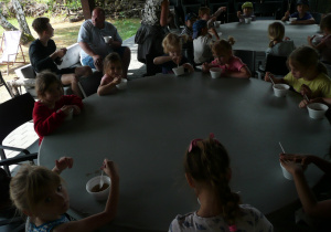 dzieci jedzą zupę przy okrągłych stołach