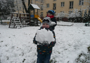 chłopczyk z ulepioną kulą śniegową
