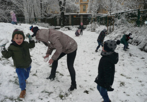 zabawa w rzucanie kulkami śniegowymi podczas pobytu Żaczków w ogrodzie przedszkolnym
