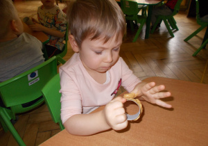 dziewczynka smaruje rolkę po papierze masłem orzechowym