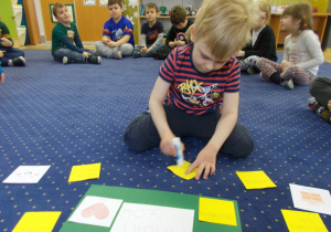dziewczynka przykleja karteczki z zapisanymi skojarzeniami dotyczącymi tematu zajęć "Magia słów"