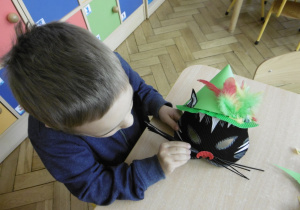 chłopczyk przygotowuje pracę na konkurs nt. "Najpiękniejsza maska karnawałowa"