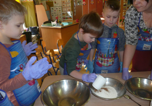 chłopiec odmierza odpowiednią ilość mąki do ciasta marechewkowego