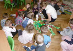 dzieci i Pani Agnieszka z grupy Tuptusie przyklejają elementy z bibuły na postac Pani Wiosny