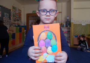 chłopiec prezentuje otrzymaną Wielkanocną Kartkę