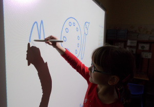 dziewczynka rysuje na tablicy interaktywnej