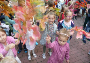 dzieci z jesiennymi liściami na tarsie podczas koncertu muzycznego