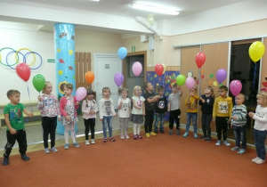 Żaczki i Juniorzy ustawione w półkolu śpiewają Hymn Przedszkolaka trzymając balony w ręce