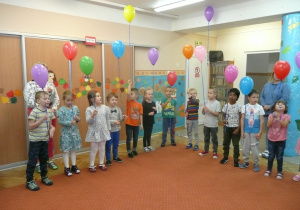 Żaczki i Juniorzy ustawione w półkolu śpiewają Hymn Przedszkolaka trzymając balony w ręce