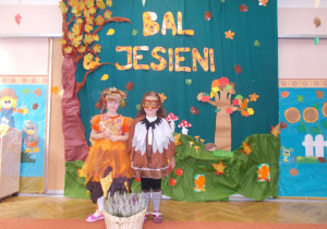 dziewczynki w strojach jesiennych na tle dekoracji z okazji balu jesieni