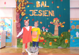 dwaj chłopcy w strojach jesiennych na tle dekoracji z okazji balu jesieni
