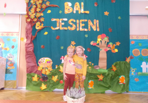 dziewczynki w strojach jesiennych na tle dekoracji z okazji balu jesieni