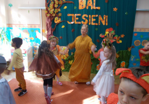 Żaczki i Juniorzy z ciocią Beatką w trojach jesiennych podczas zabaw na sali gimnastycznej z okazji balu jesieni