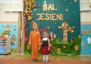 dziewczynki w strojach jesiennych na tle dekoracji z okazji Balu Jesieni