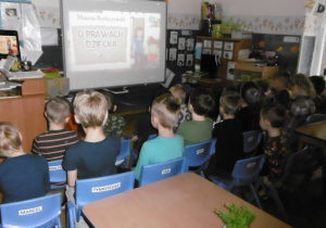 Juniorzy oglądaja film na tablicy interaktywnej "O prawach dziecka"