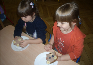 "Misiowy poczęstunek" - dzieci jedzą kanapki z serkiem czekoladowym i bananem