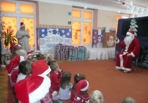 Mikołaj na tle dekoracji zimowej oraz prezentów dla przedszkolaków