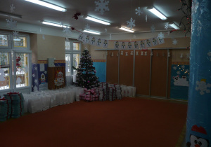Świąteczna dekoracja na sali gimnstycznej - choinka, pod którą zanjdują sie prezenty dla przedszkolaków