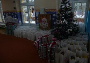 Świąteczna dekoracja na sali gimnstycznej - choinka, pod którą zanjdują sie prezenty dla przedszkolaków