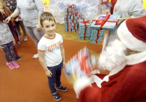 chłopczyk odbiera prezent od Św. Mikołaja