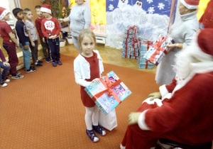 dziewczynka odbiera prezent od Św. Mikołaja