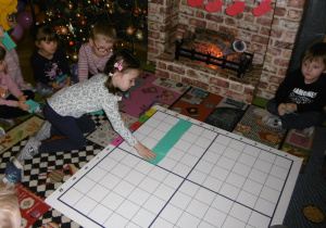 dziewczynka na dywanie układa kartoniki wg określonych kodów