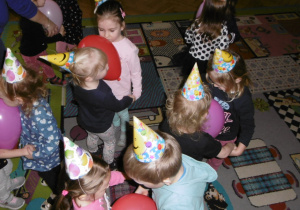 Tuptusie tańczą w rytm muzyki w czapeczkach urodzinowych