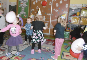Tuptusie tańczą w rytm muzyki w czapeczkach urodzinowych