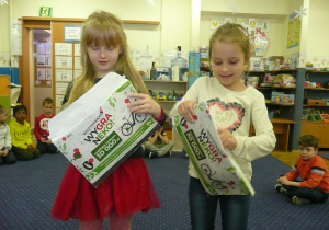 dwie dziewczynki otwierają listy od dzieci ze Szczecina z kartkami z Iskierkami Emocji