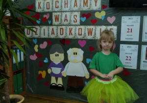 dziewczynka w kolorowym stroju podczas recytacji wiersza dla Babci i Dziadka