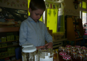 chłopczyk przygotowuje słoiczek z miodem dla Babci i Dziadka
