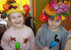 dwie dziewczynki w kapeluszach z owocami
