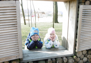Dwie dziewczynki w drewnianym okienku