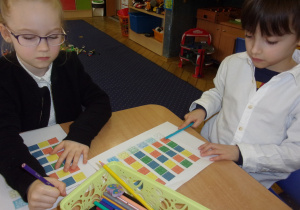 dzieci kolorują klocki lego przy stolikach