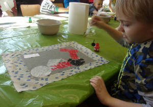 chłopiec maluje farbami plakatowymi