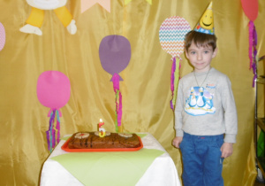 chłopczyk w czapeczce urodzinowej przy torcie