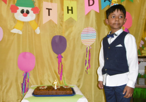 chłopczyk w czapeczce urodzinowej przy torcie