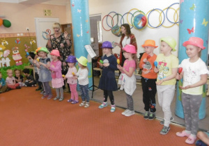 dzieci ustawione w szeregu w kapeluszach na głowie