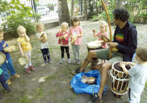 Tuptusie w ogrodzie przedszkolnym podczas zajęc Capoeira graja na instrumentach perkusyjnych