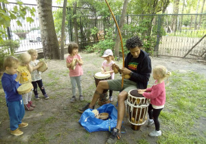 Tuptusie w ogrodzie przedszkolnym podczas zajęc Capoeira graja na instrumentach perkusyjnych
